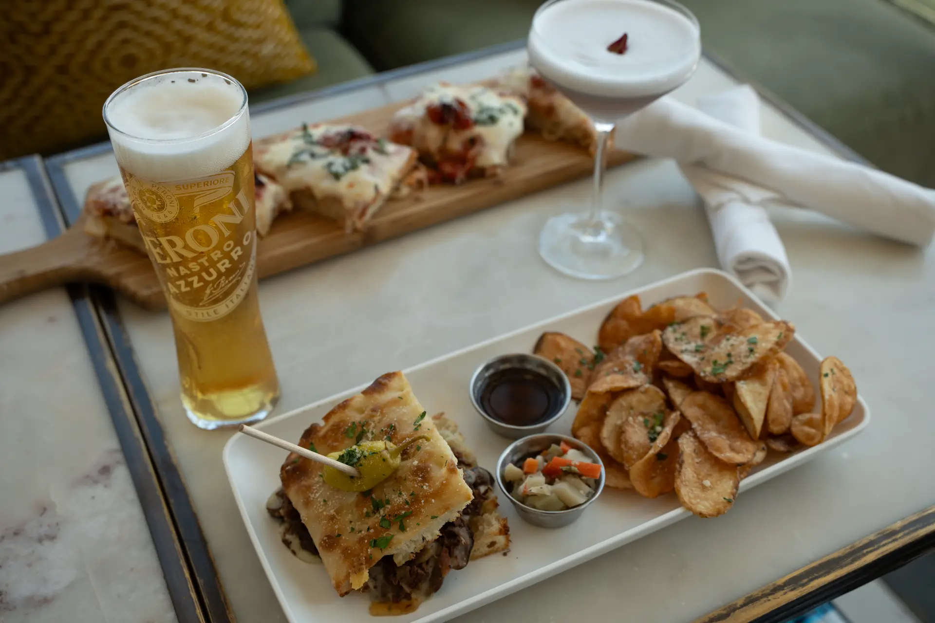 Steak sandwich with chips and cocktails at Candle Bar